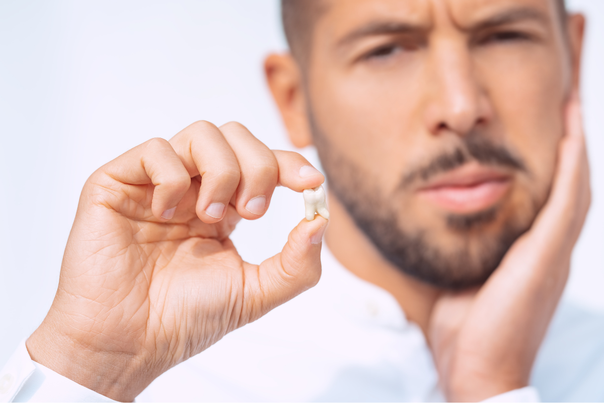 Man examining teeth with finger, concerned expression, dental health concept